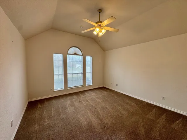 a view of an empty room with a chandelier fan