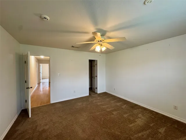 an empty room with a chandelier fan and a chandelier fan