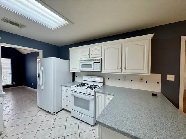 a kitchen with cabinets and white appliances