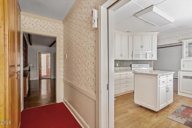 a kitchen with white cabinets sink and stove