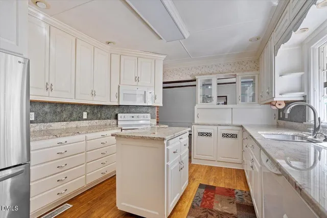 a kitchen with white cabinets and white appliances