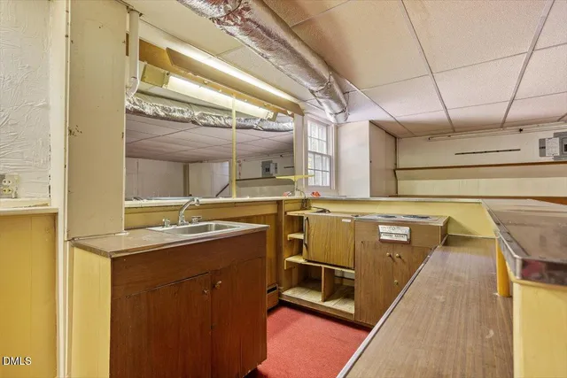 a view of a house with a small yard plants and large tree