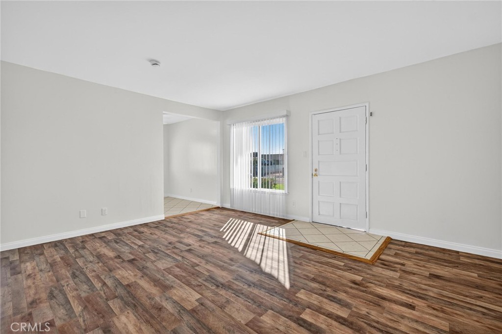 1613 West Piru Street Compton, CA 90222 - Photo 18 of 40 a view of an empty room with wooden floor and a window