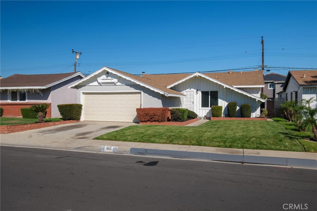 1613 West Piru Street Compton, CA 90222 - Photo 2 of 40 a front view of a house with a yard and garage