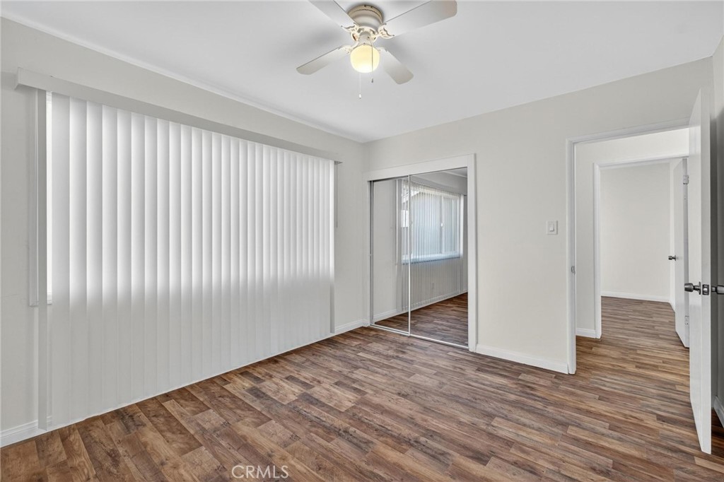1613 West Piru Street Compton, CA 90222 - Photo 24 of 40 an empty room with wooden floor chandelier fan and windows