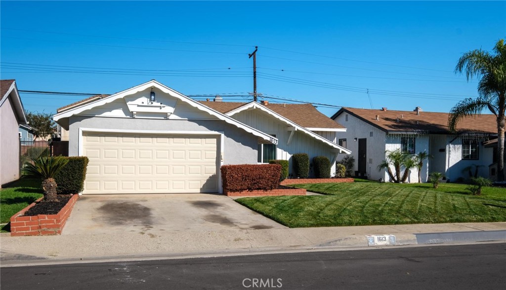 1613 West Piru Street Compton, CA 90222 - Photo 3 of 40 a front view of a house with a yard