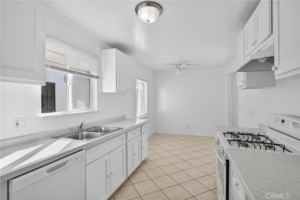 1613 West Piru Street Compton, CA 90222 - Photo 35 of 40 a kitchen with sink refrigerator and stove