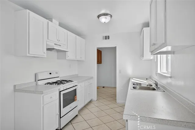 a kitchen with stainless steel appliances granite countertop a sink stove and cabinets