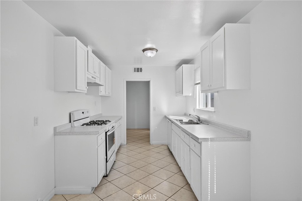 1613 West Piru Street Compton, CA 90222 - Photo 37 of 40 a kitchen with stainless steel appliances granite countertop a sink stove and cabinets