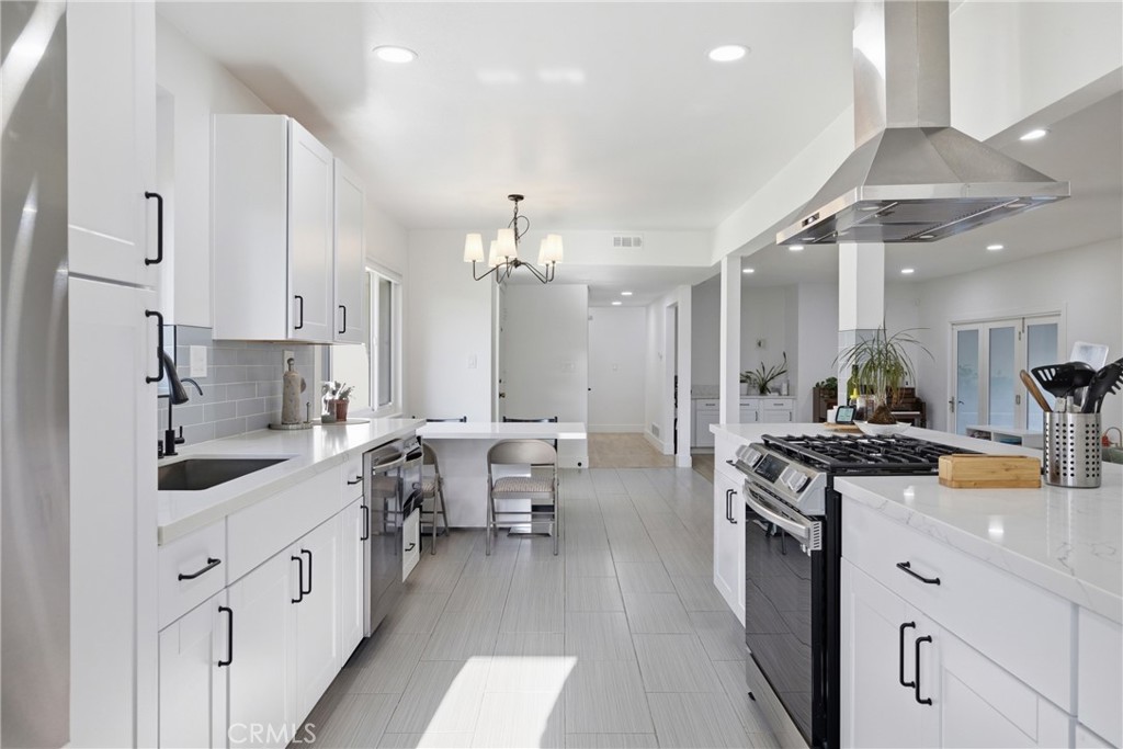 384 Colorado Street Arcadia, CA 91007 - Photo 22 of 51 a large white kitchen with stainless steel appliances a stove a sink dishwasher and white cabinets with wooden floor