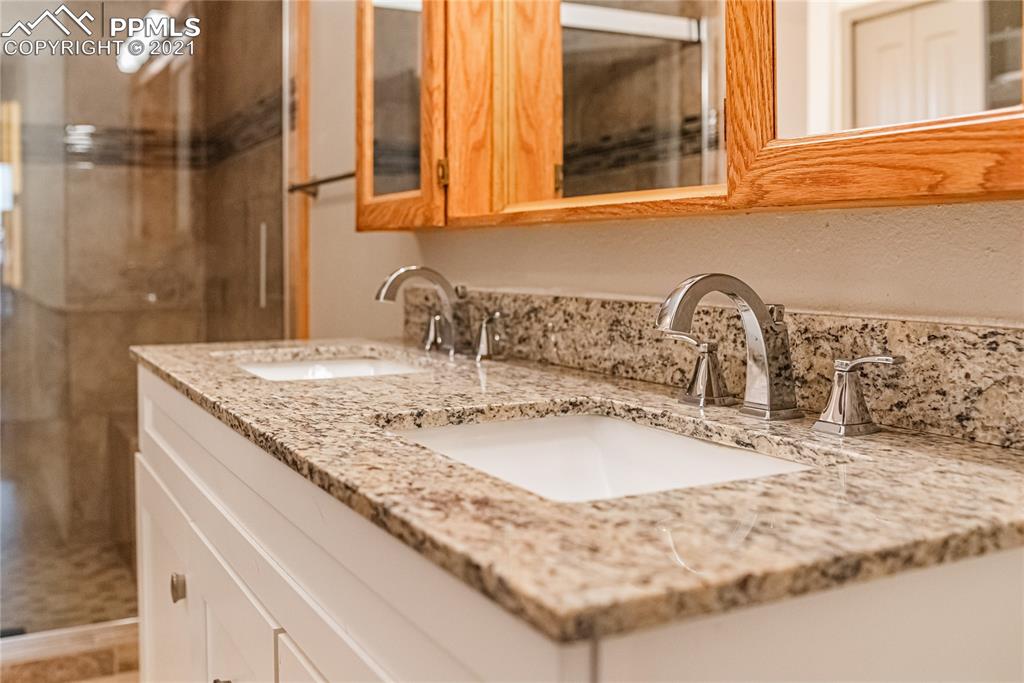 1808 County Road South Rush, CO 80833 - Photo 13 of 36 a bathroom with a granite countertop sink and a mirror