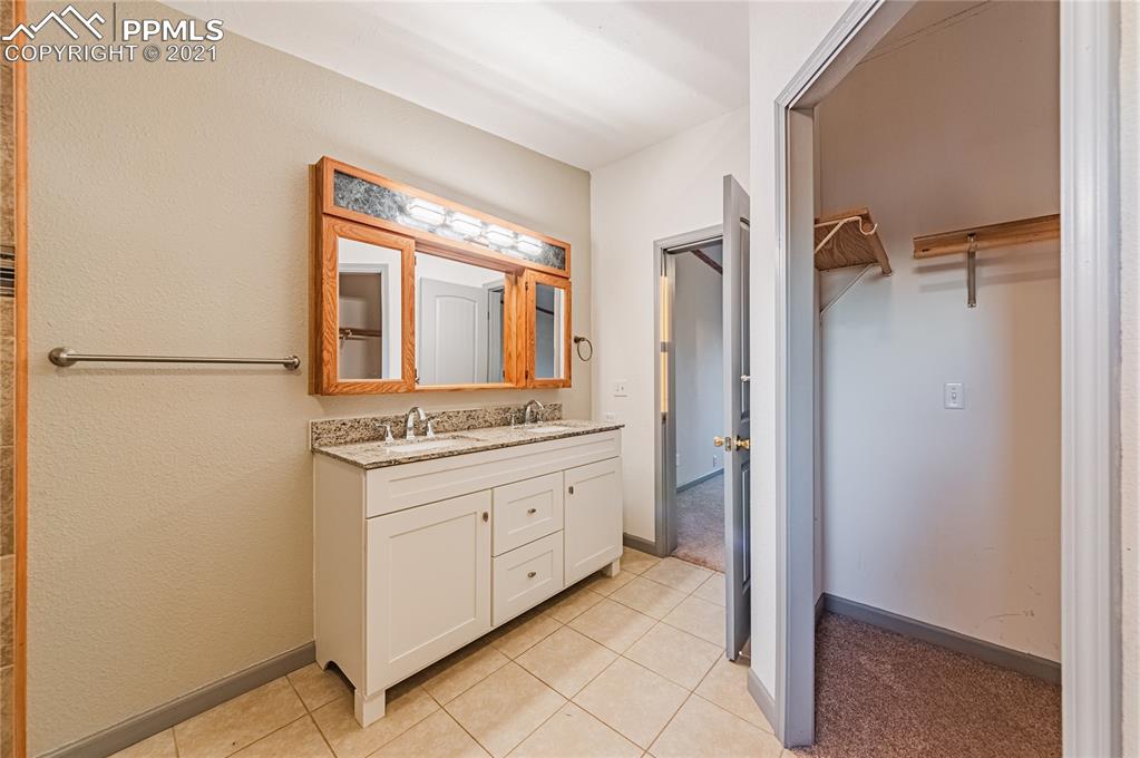 1808 County Road South Rush, CO 80833 - Photo 15 of 36 a bathroom with a granite countertop sink and a mirror