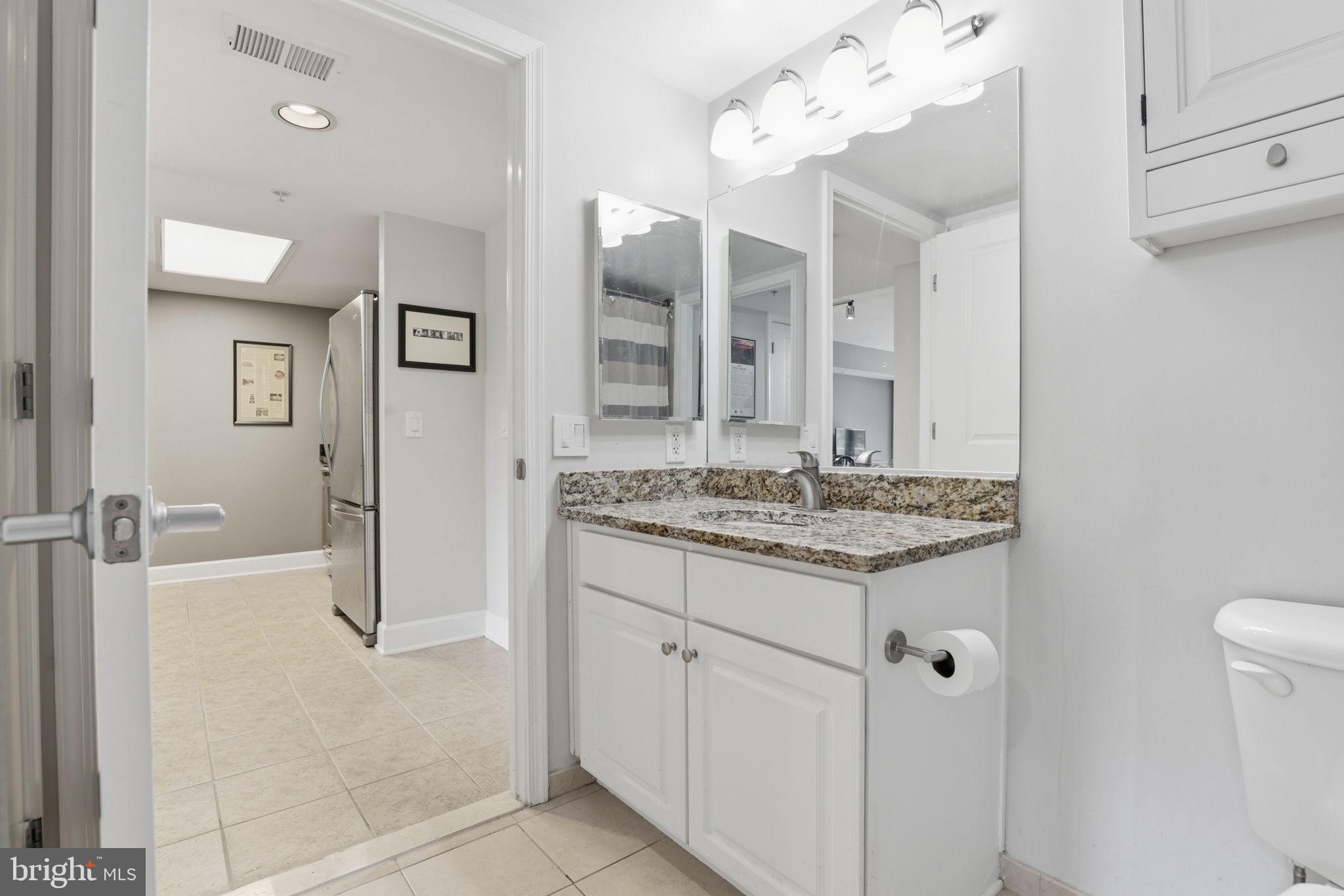 11800 Sunset Hills Road, Unit 218 Reston, VA 20190 - Photo 23 of 38 a bathroom with a granite countertop sink and a mirror