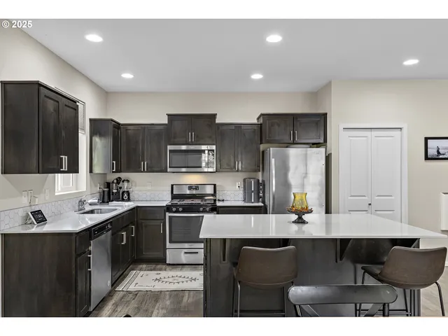 a kitchen with stainless steel appliances kitchen island granite countertop a sink and cabinets
