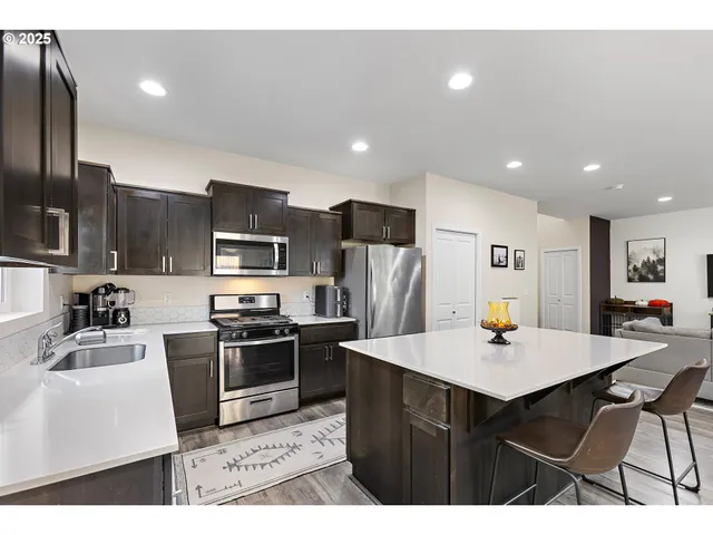 a kitchen with stainless steel appliances a sink counter space and a refrigerator