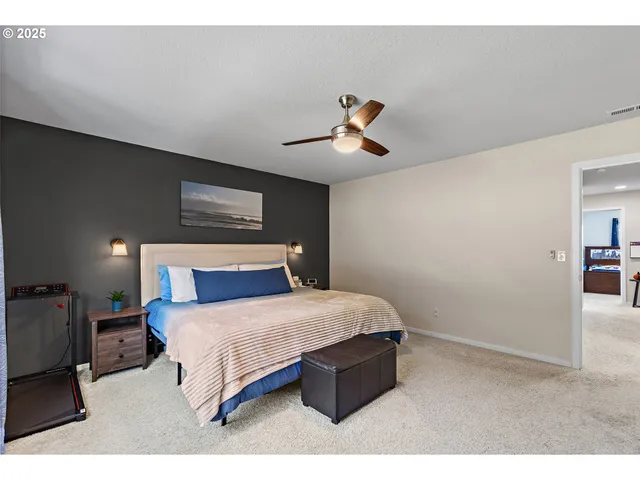 a bedroom with a bed and painting on the wall