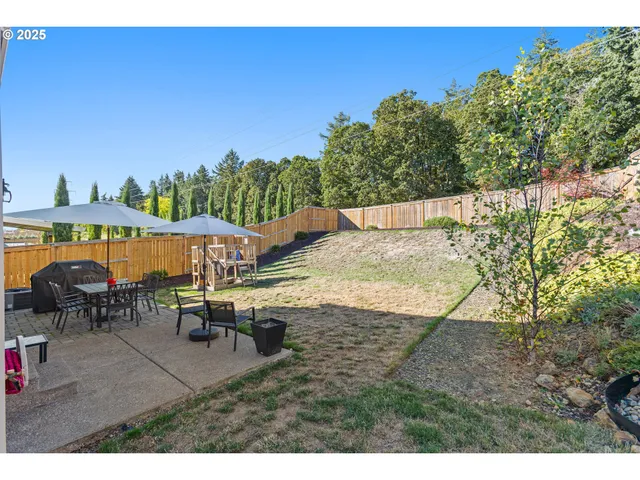 a view of a house with backyard and sitting area