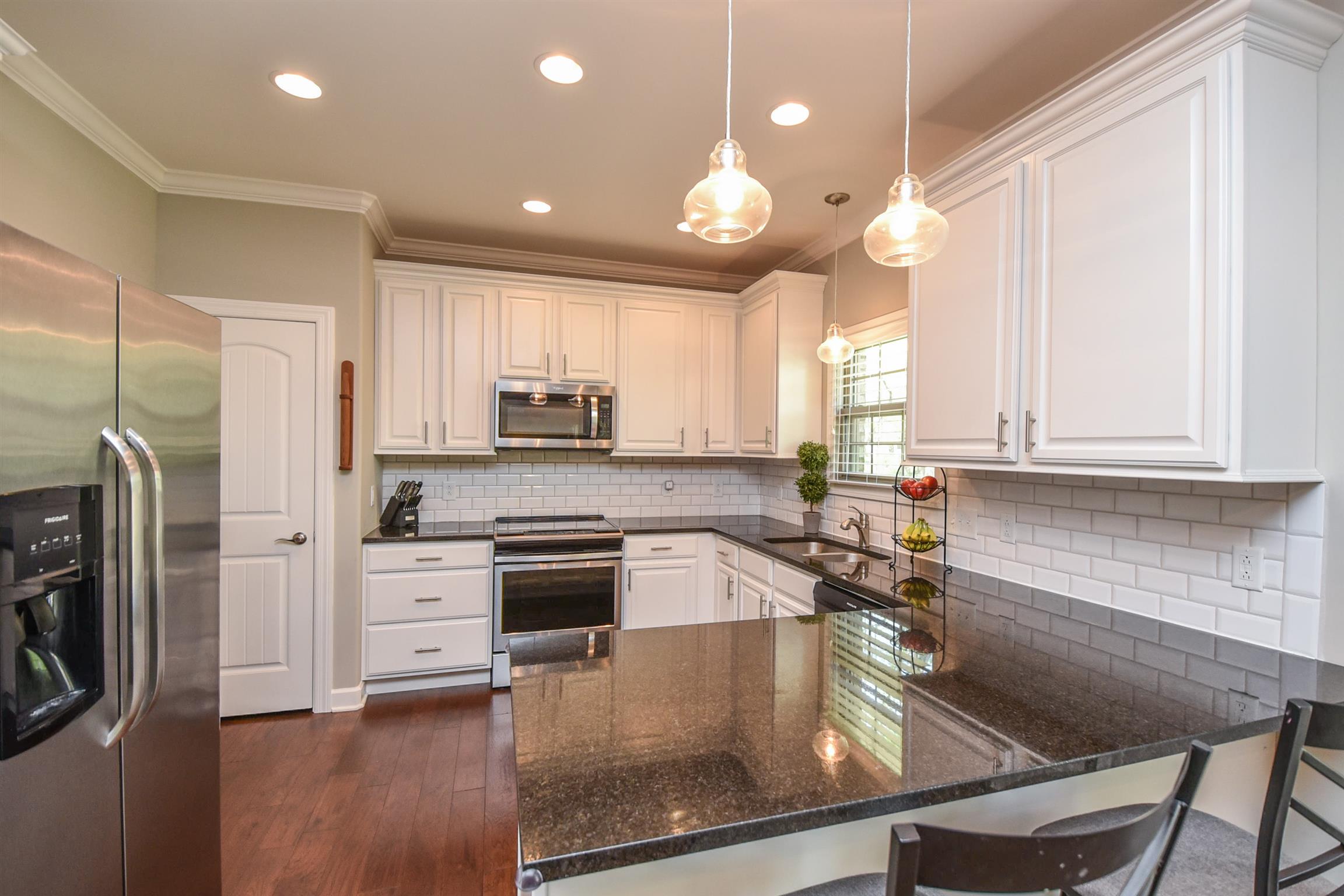 310 Independence Street Springfield, TN 37172 - Photo 17 of 29 a kitchen with stainless steel appliances granite countertop a refrigerator a sink dishwasher a stove and white cabinets with wooden floor