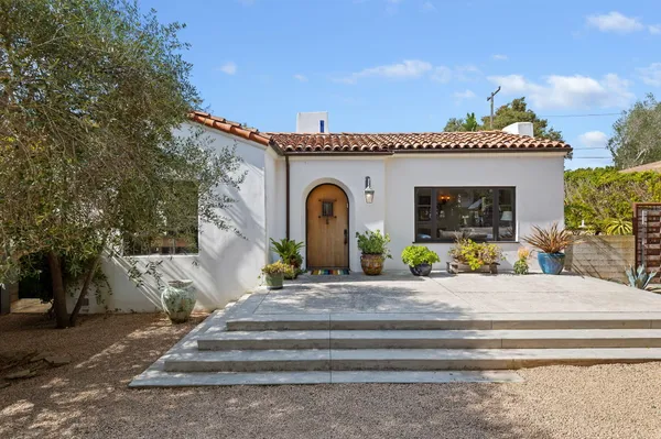 a front view of a house with plants
