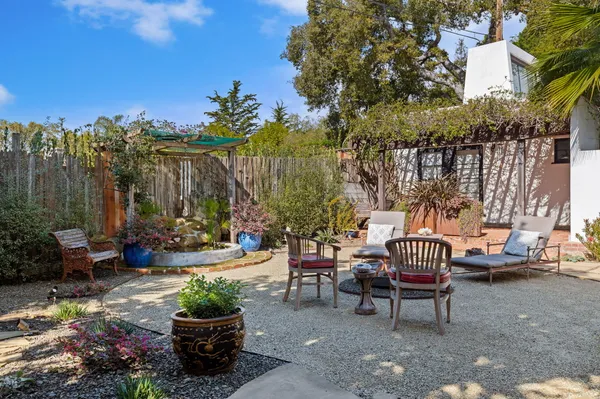 a view of a patio with couple of chairs and potted plants