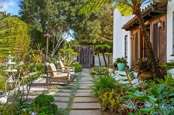 a backyard of a house with fountain table and chairs