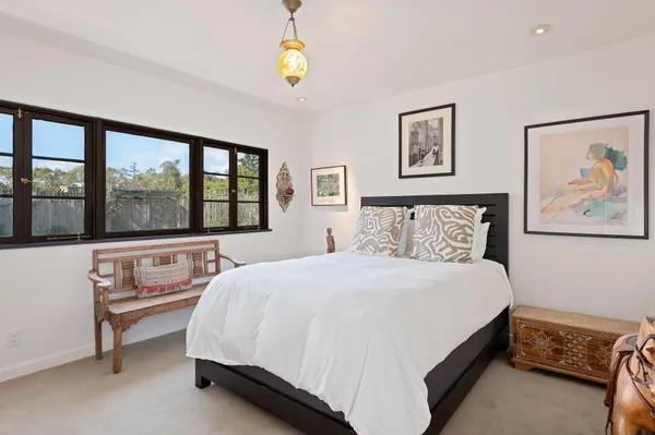 a bedroom with a bed and a large window