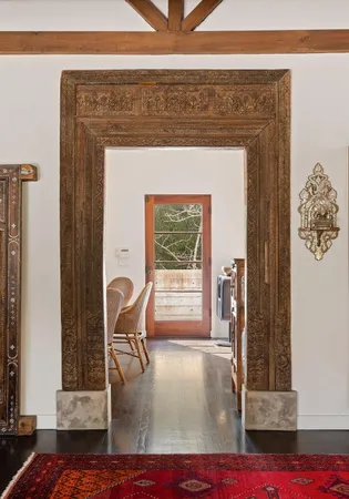 a dining room with furniture a potted plant and wooden floor