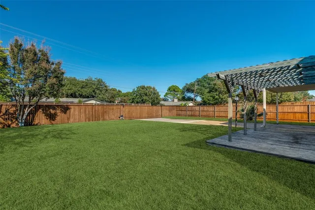 a view of a backyard with couches plants and large tree