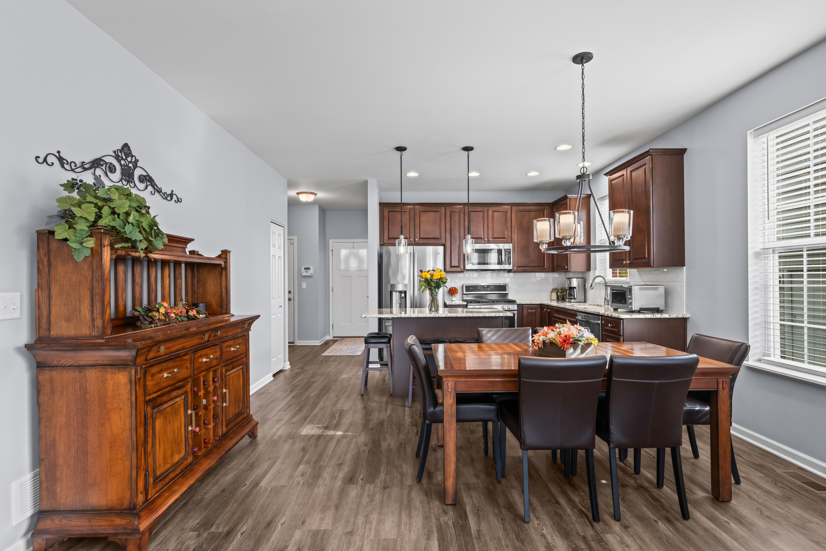 460 Mahogany Drive Algonquin, IL 60102 - Photo 8 of 29 a dining room with wooden floor a chandelier a wooden table and chairs