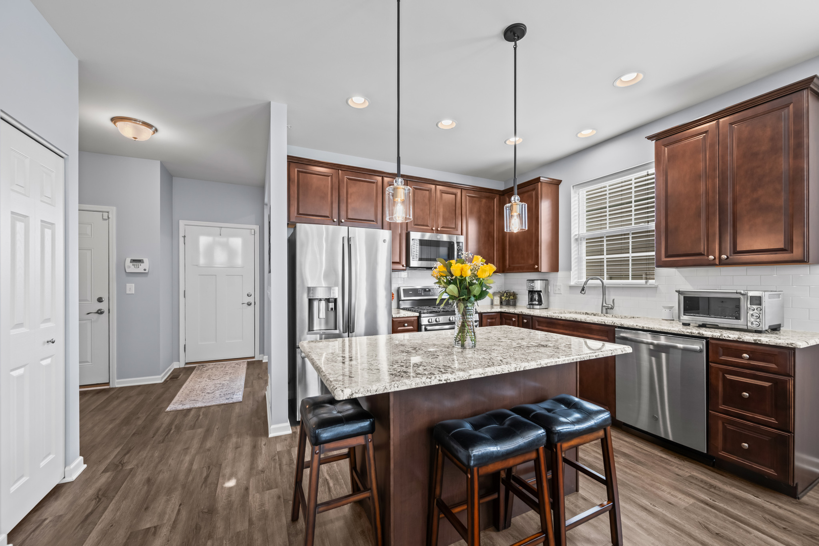 460 Mahogany Drive Algonquin, IL 60102 - Photo 10 of 29 a kitchen with granite countertop a table chairs stainless steel appliances and wooden floor