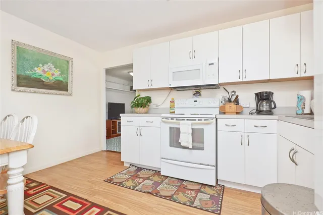 a kitchen with cabinets appliances and a wooden floor