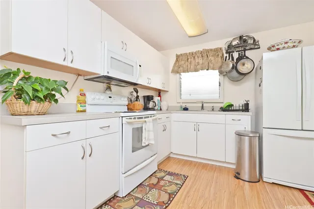 a kitchen with white cabinets and white appliances