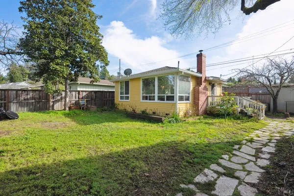 a view of a house with backyard and a tree