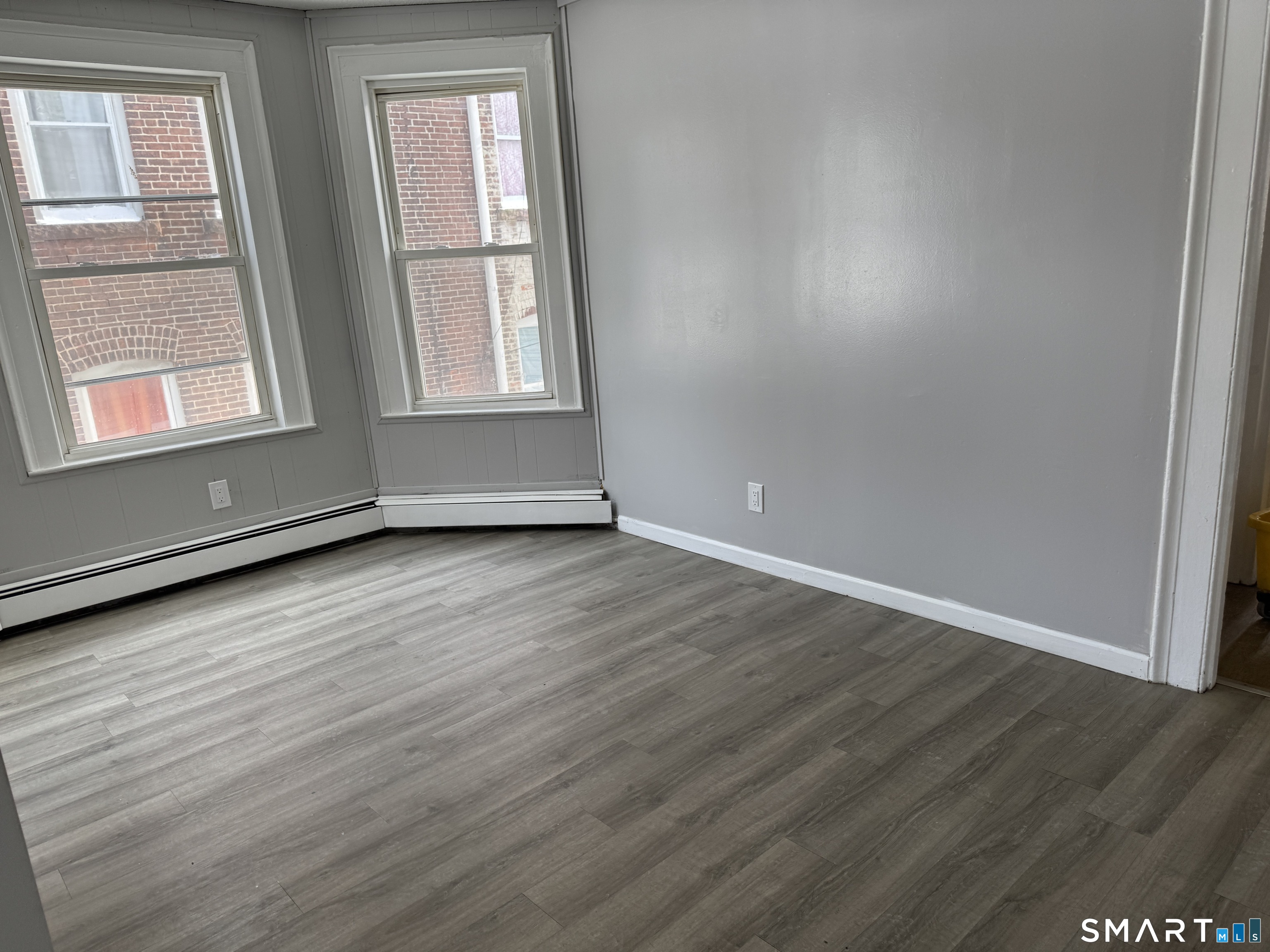 107 Hamilton Street, Unit 2 Hartford, CT 06106 - Photo 7 of 9 an empty room with wooden floor and windows