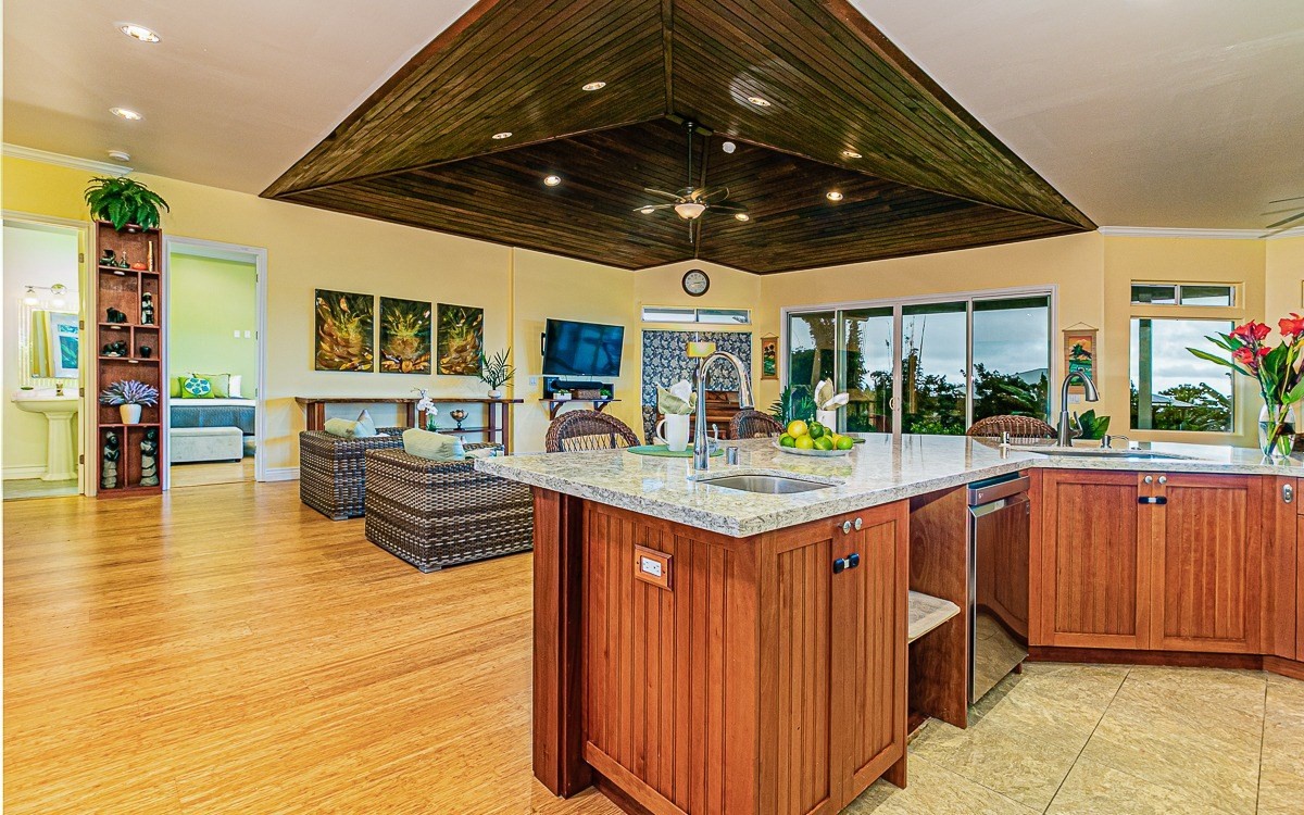 28-256 Akaka Falls Road Honomu, HI 96728 - Photo 12 of 26 a kitchen with stainless steel appliances granite countertop a sink and wooden cabinets