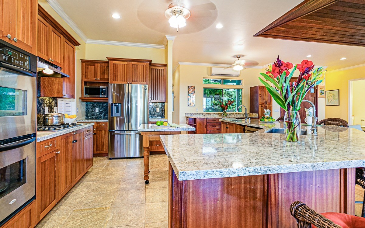 28-256 Akaka Falls Road Honomu, HI 96728 - Photo 13 of 26 a kitchen with stainless steel appliances granite countertop a sink dishwasher and a refrigerator