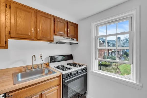 a kitchen with granite countertop a stove sink and cabinets