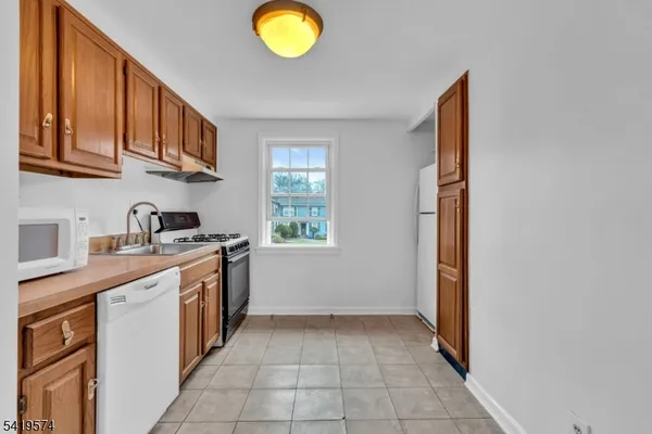 a kitchen with stainless steel appliances granite countertop a sink stove and microwave