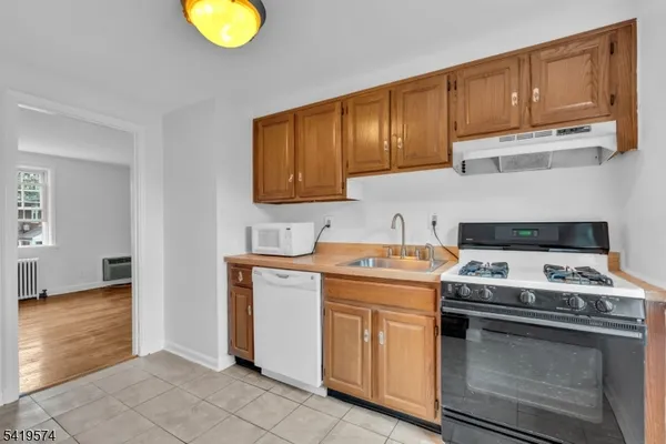 a kitchen with granite countertop wooden cabinets stainless steel appliances and a window