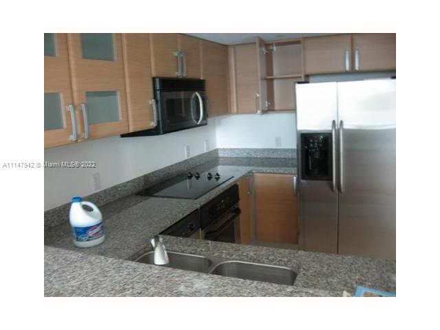 a kitchen with stainless steel appliances kitchen island granite countertop a refrigerator and a stove