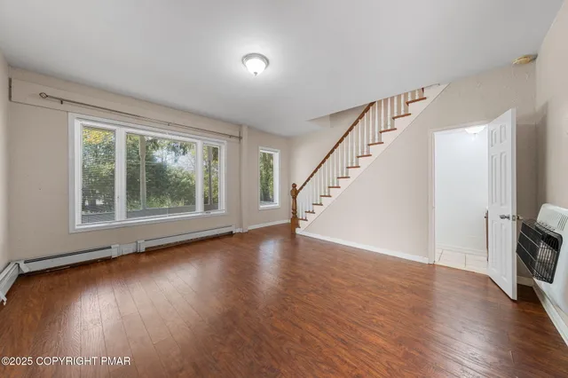 a view of a room with wooden floor and window