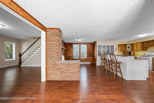 a view of a living room and kitchen with furniture and wooden floor
