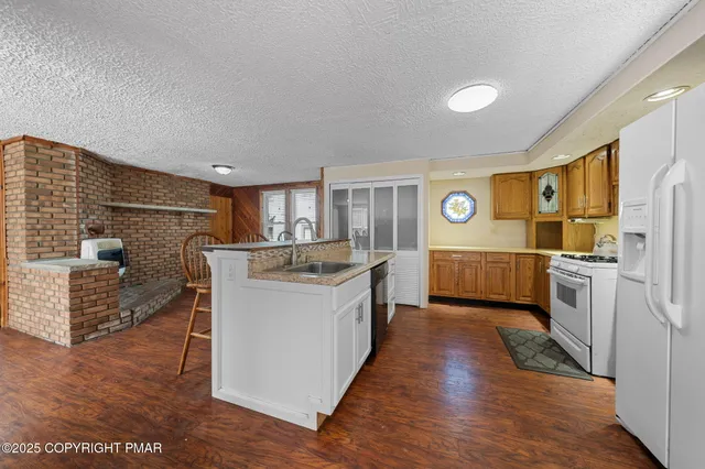a kitchen with stainless steel appliances a sink a stove top oven a counter space and cabinets
