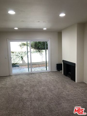 a view of an empty room with a fireplace and a large window