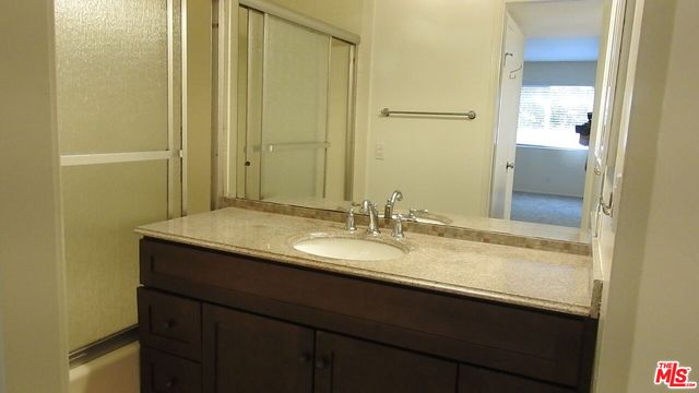 a bathroom with a granite countertop sink and a mirror