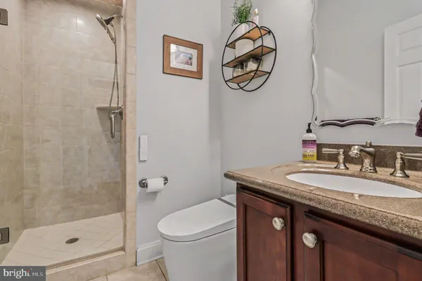 a bathroom with a granite countertop sink a toilet and a mirror