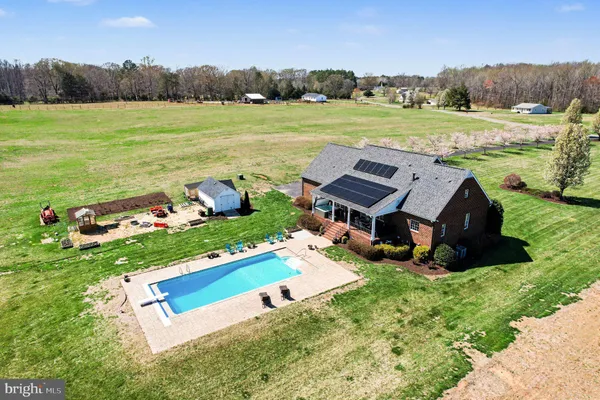 an aerial view of a house with garden space and pool