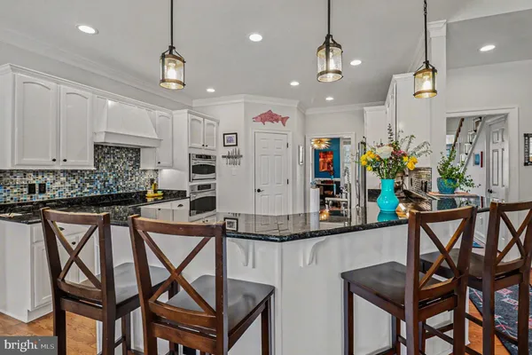 a kitchen with stainless steel appliances granite countertop table chairs sink and cabinets