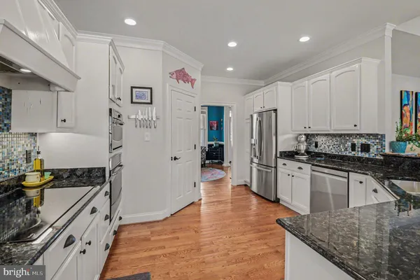 a kitchen with stainless steel appliances granite countertop a refrigerator and a stove top oven