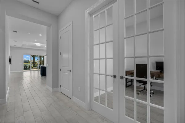 a view of a hallway with wooden floors and cabinet